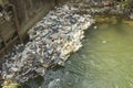 A various plastic and rubber garbage on the dam in the river. ecological catastrophy