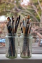 Various professional paint brushes in the transparent jars Royalty Free Stock Photo
