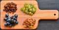 Various raisins, vine berries and almonds on chopping board Royalty Free Stock Photo