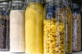 Various raw cereals, grains, beans and pasta for healthy cooking in glass jars on the kitchen shelf.Clean food, vegetarian, vegan,