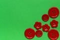 Various red sewing buttons on green background Royalty Free Stock Photo