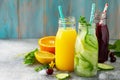 Various refreshments drinks - detox cucumber water, cherry juice and orange juice on stone table.