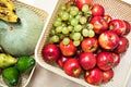 Various ripe fruits and vegetables (apples, pears, pumpkins, avocados, bananas, grapes) are packed in a wicker container Royalty Free Stock Photo