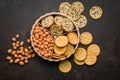 Various salty snacks in a round bowl on black table Royalty Free Stock Photo