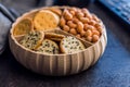Various salty snacks in a round bowl on black table Royalty Free Stock Photo