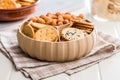 Various salty snacks in a round bowl on white table Royalty Free Stock Photo