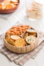Various salty snacks in a round bowl on white table Royalty Free Stock Photo