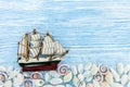 Various seashells with ship on blue rustic wooden background