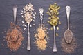Various seeds - sesame, flax seed, sunflower seeds, pumpkin seed, chia in spoons on black background. Top view