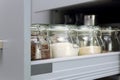 Various seeds in storage jars in hutch, white modern kitchen in background. Smart kitchen organization Royalty Free Stock Photo