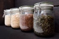 Various seeds in storage jars in pantry, dark wooden background. Smart kitchen organization Royalty Free Stock Photo