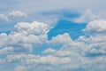 Various shape fluffy cummulus clouds accumulating on blue summer sky