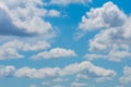 Various shape fluffy cummulus clouds accumulating on blue summer sky