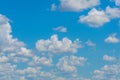 Various shape fluffy cummulus clouds accumulating on blue summer sky