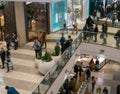 Various shoppers in motion as they wall through a crowded mall