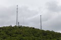 Various sized towers atop a lush green mountain.