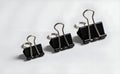 Black binder clips in various sizes, perfect for paper fastening. Royalty Free Stock Photo