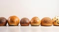 Various small fresh buns with a sprinkle of seeds in a row, white background isolate. AI generated.