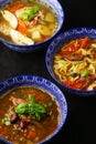 Various soup on black background top view. bean sooup with meat, lagman soup with beef and noodles and other traditional dish in