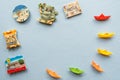 Various souvenir magnets and paper ships arranged on the blue background