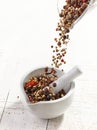 Various spices falling into mortar and pestle Royalty Free Stock Photo