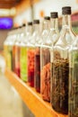 Various spices in the glass bottles on the wooden shelf Royalty Free Stock Photo