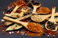 Various spices spilled on black background,  with wooden spoons and scoop Royalty Free Stock Photo