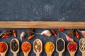 Various spices in spoons on dark stone table. Royalty Free Stock Photo