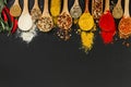 Spices in wooden spoons on black background. Royalty Free Stock Photo