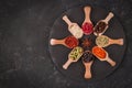 Various spices in wooden spoons on dark stone table Royalty Free Stock Photo