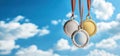 Various sports medals, gold, silver, bronze against the background of a bright blue sky, symbol of victory