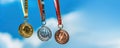 Various sports medals, gold, silver, bronze against the background of a bright blue sky, symbol of victory Royalty Free Stock Photo