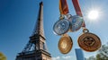 Various sports medals, gold, silver, bronze against background of Eiffel Tower under blue sky. Summer Olympics in Paris Royalty Free Stock Photo