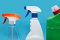 Various spray bottles with detergent on a blue background