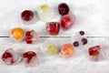 Berries frozen in ice cubes with mint on wooden table background. Royalty Free Stock Photo