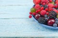 Various summer Fresh berries in a bowl on rustic wooden table. Antioxidants, detox diet, organic fruits. Royalty Free Stock Photo