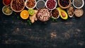 Various superfoods. Dried fruits, nuts, beans, fruits and vegetables. On a black wooden background.