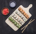 Various sushi sets, dill, salmon, crab on a white cutting board Asian food on wooden rustic background top view close up Royalty Free Stock Photo