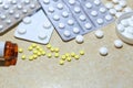 Various tablets - analgesics, antidepressants, vitamins, antiviral drugs scattered on the table.