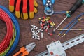 Electrician tools with red and blue wire laid out on a wooden surface of dark color. top view Royalty Free Stock Photo