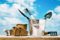 Various tools for working in the garden on a wooden table against a blue sky with clouds Royalty Free Stock Photo