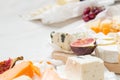 Various types of cheese with fruits on the wooden white table with copy space. Royalty Free Stock Photo