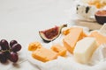 Various types of cheese with fruits on the wooden white table with copy space. Royalty Free Stock Photo