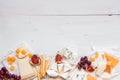 Various types of cheese with fruits on the wooden white table with copy space. Top view Royalty Free Stock Photo