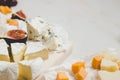 Various types of cheese with fruits on the wooden white table with copy space. Royalty Free Stock Photo