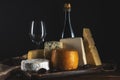 Various types of cheese with glass of wine on rustic wooden table. Dark background Royalty Free Stock Photo