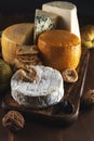 Various types of cheese on rustic wooden table. Dark background Royalty Free Stock Photo