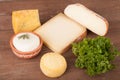 Various types of cheese on a wooden background with parsley Royalty Free Stock Photo