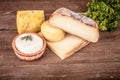 Various types of cheese on a wooden background with parsley.Tinted Royalty Free Stock Photo