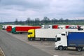 Various types and colors of cabins. Trucks parked in a row. Truck stop. Break in a trip